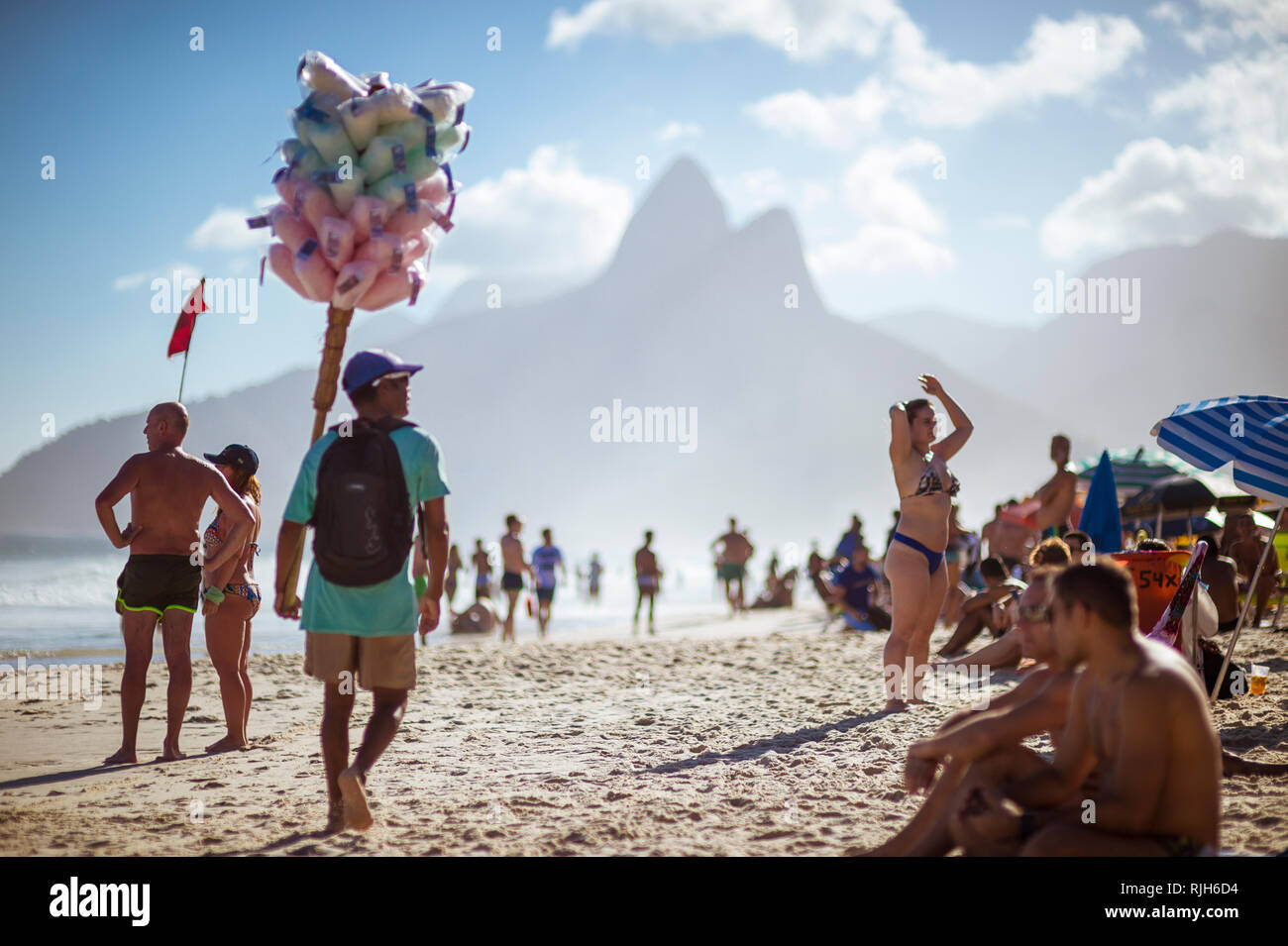 RIO DE JANEIRO - Gennaio 2018: una spiaggia brasiliana venditore a vendere il cotone Candy Floss passeggiate passato i potenziali clienti della spiaggia di Ipanema. Foto Stock