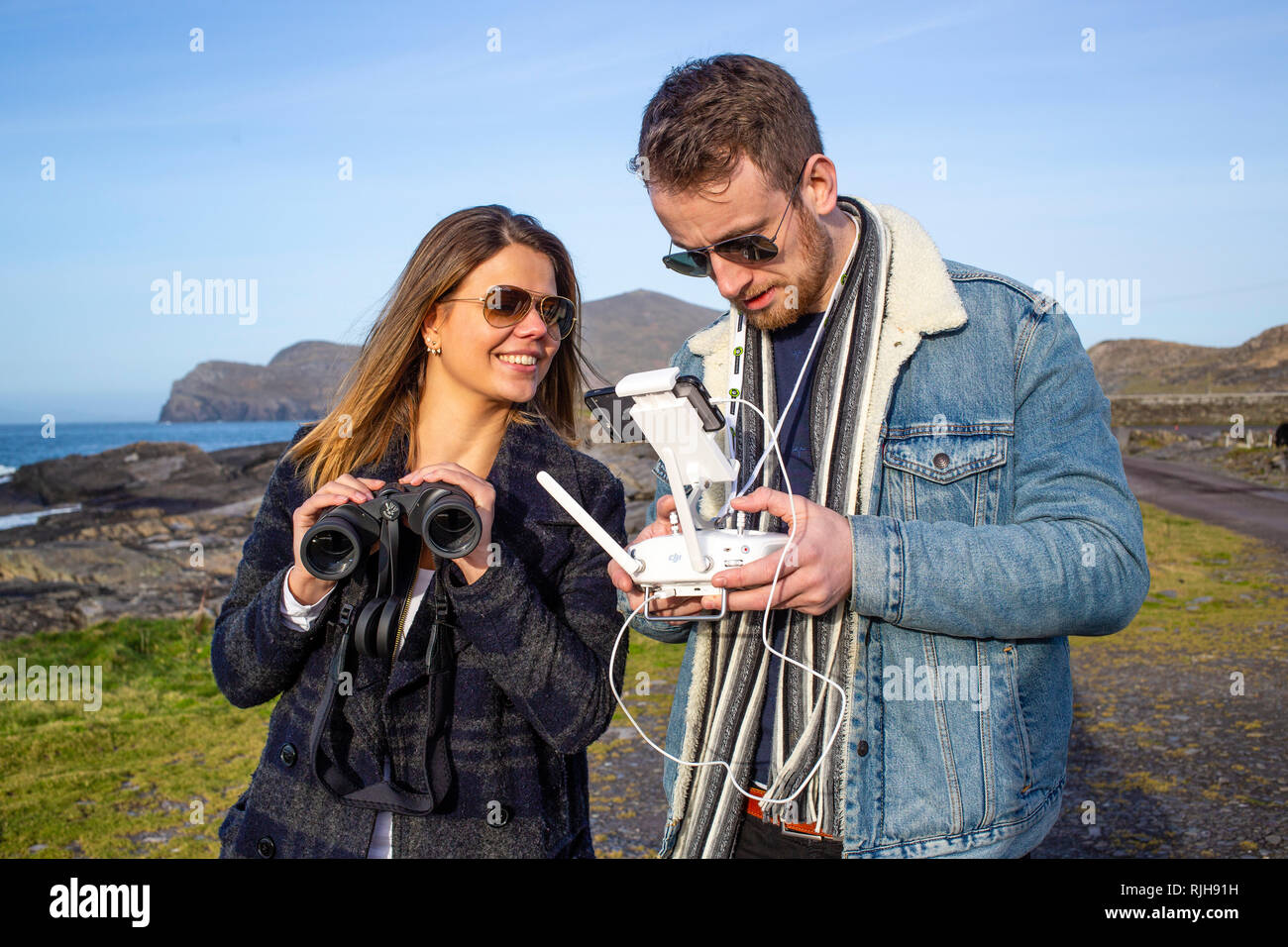 Giovane coppia attraente battenti un drone, Valentia Island, nella contea di Kerry, Irlanda Foto Stock