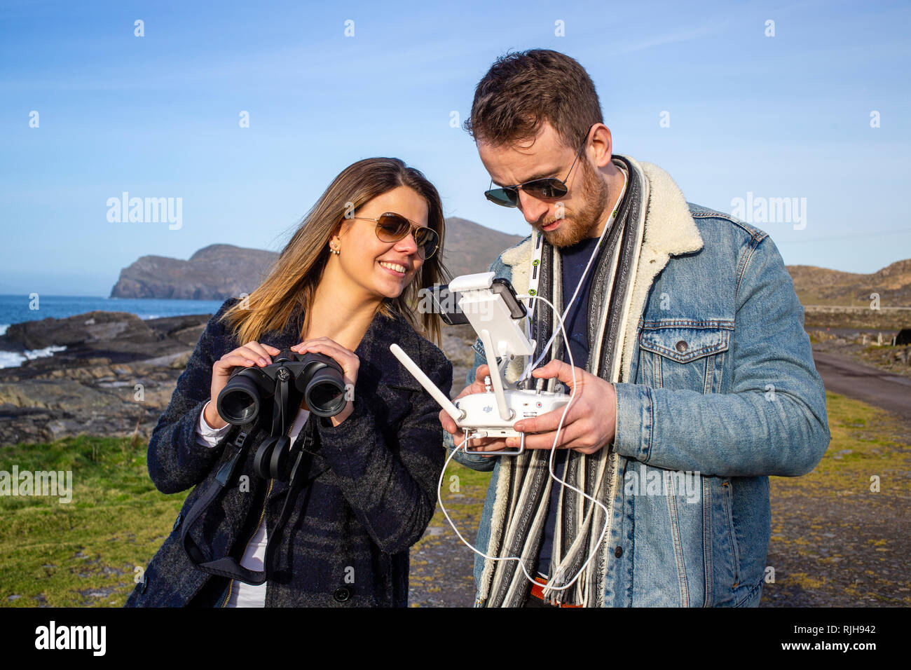 Giovane coppia attraente battenti un drone, Valentia Island, nella contea di Kerry, Irlanda Foto Stock