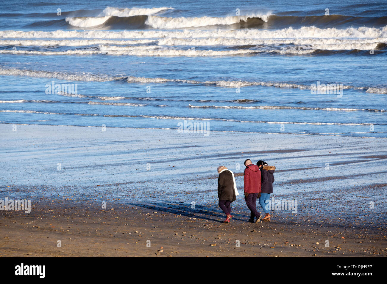 Walkers sulla spiaggia a Seaton Carew, Hartlepool, County Durham, Regno Unito Foto Stock