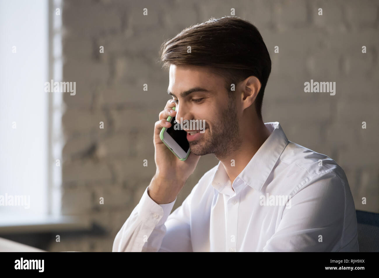 Dipendente sorridenti parlare su smartphone lavoro in ufficio Foto Stock