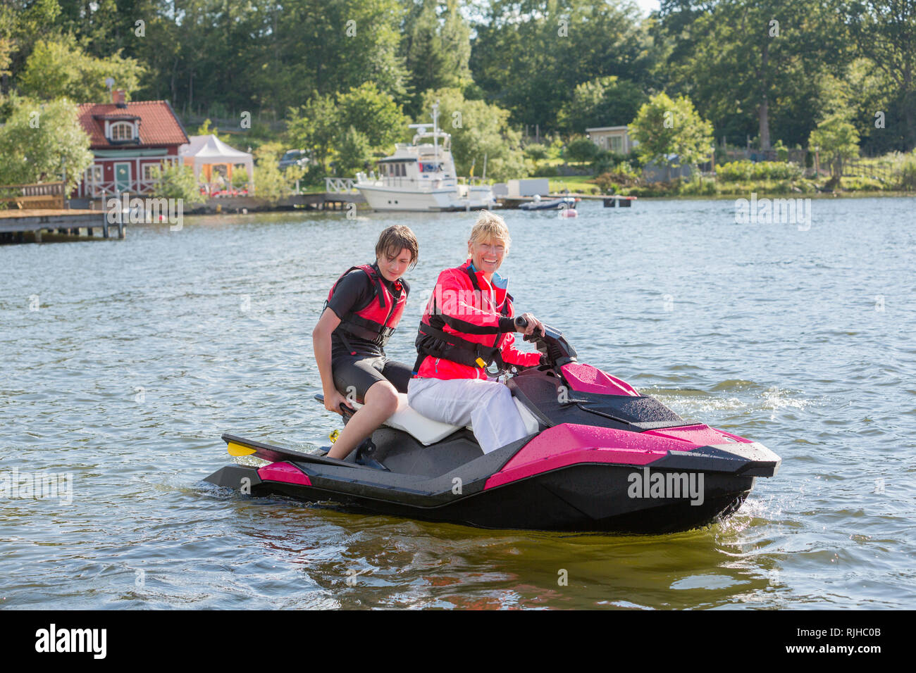 Madre e figlio adolescente su jet ski Foto Stock