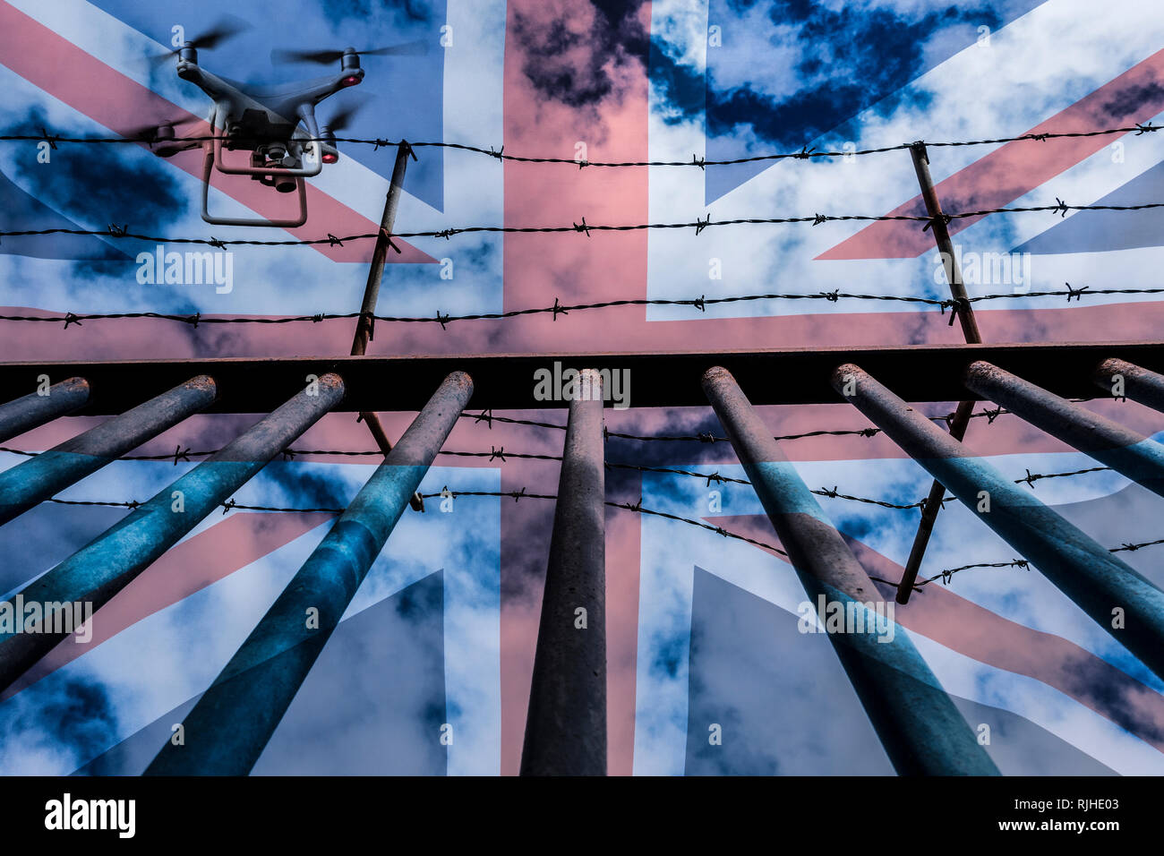 Drone sorvolano acciaio recinzione sbarrata e rabboccato con filo spinato. Concetto di immagine: la droga nelle carceri, sorveglianza, spionaggio, il controllo di frontiera... Foto Stock