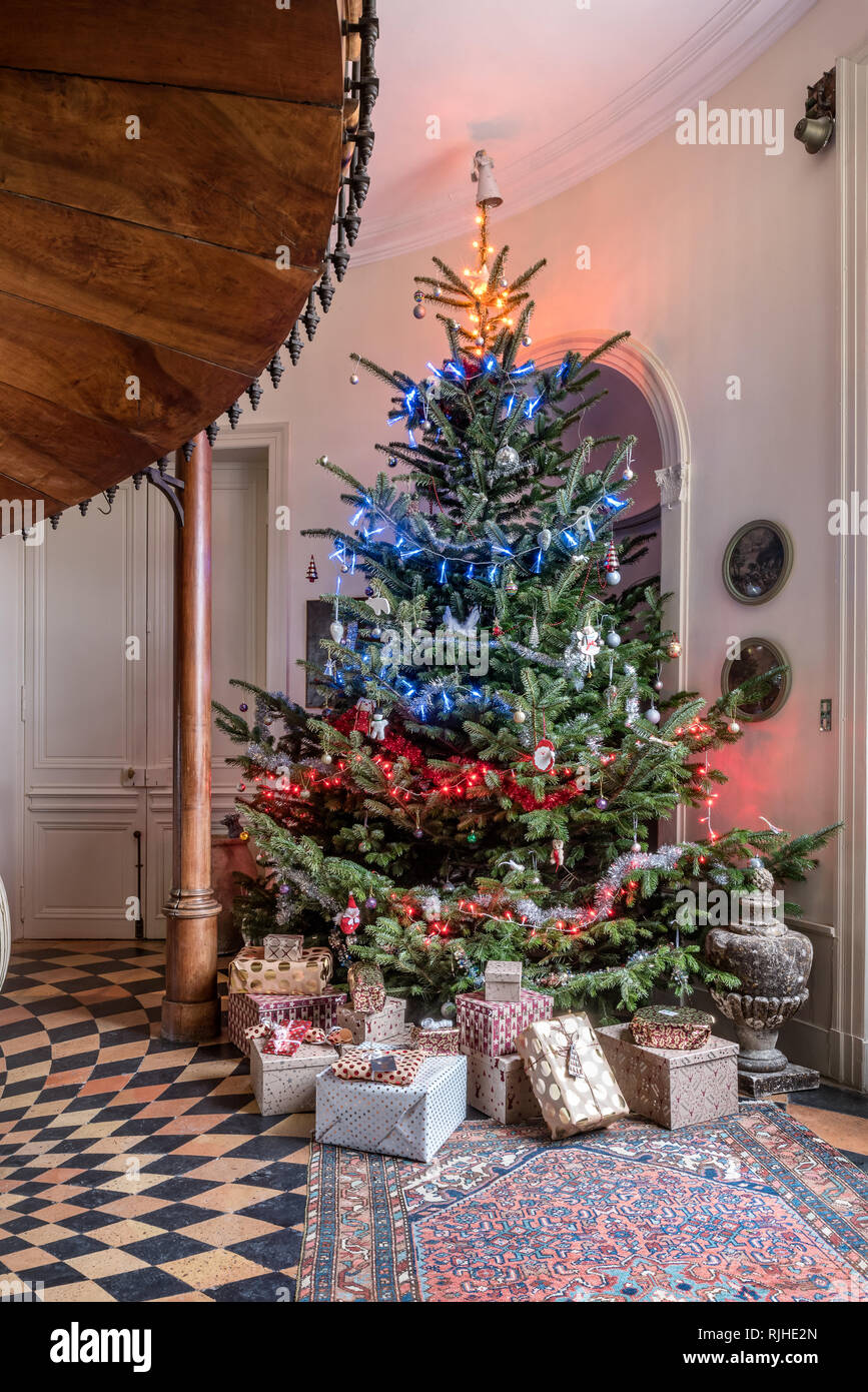 Dieci piedi albero di Natale decorato con rosso, bianco e luci blu accoglie gli ospiti che entrano in sala. Foto Stock