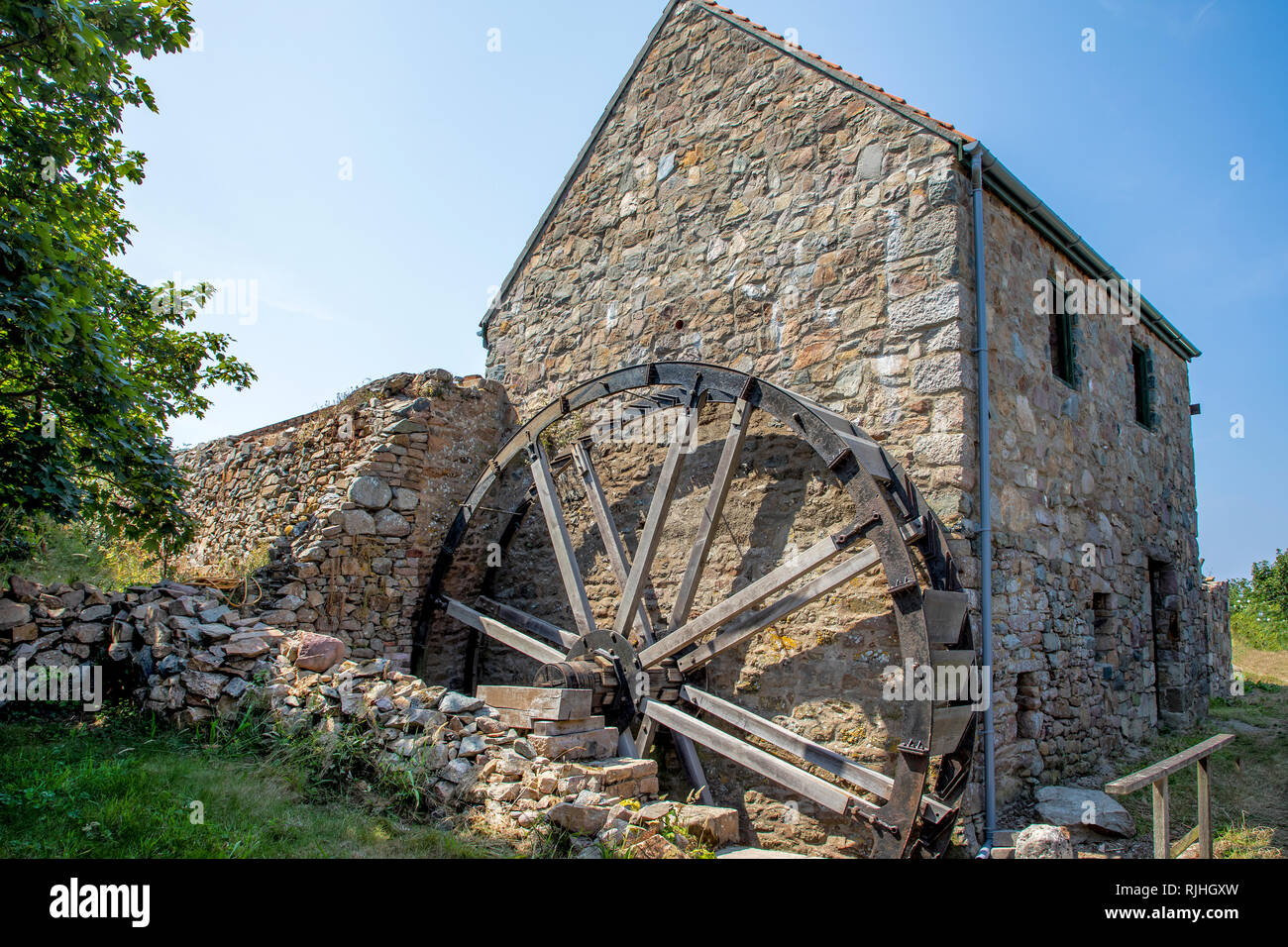 Il mulino e la ruota di acqua essendo ricostruito in Alderney. Foto Stock