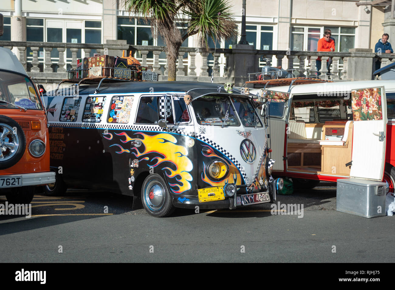 Un dipinto personalizzato split-screen​ Volkswagen VW camper con fiamme gialle parcheggiato su Madeira Drive in Brighton, Sussex, Inghilterra. Foto Stock