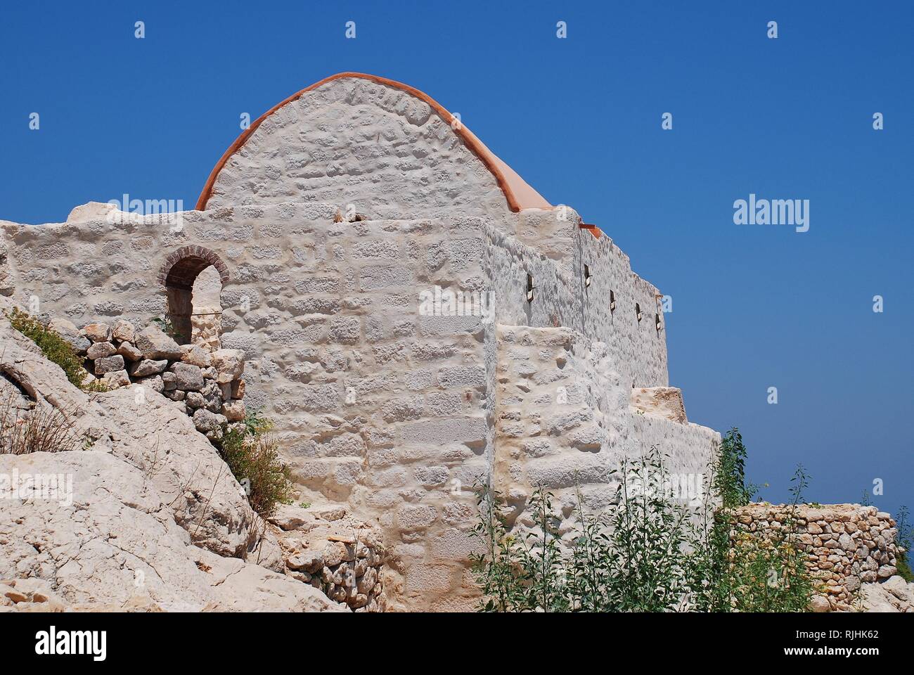 La cappella restaurata nei resti del Crociato medievale castello dei cavalieri sopra Chorio sull'isola greca di Halki. Foto Stock