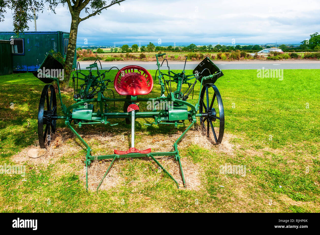 Ristrutturato di recente e dipinto di macchine agricole in appoggio sull'erba tra gli altri attrezzi agricoli vicino al fabbro del negozio a Gretna Green Foto Stock