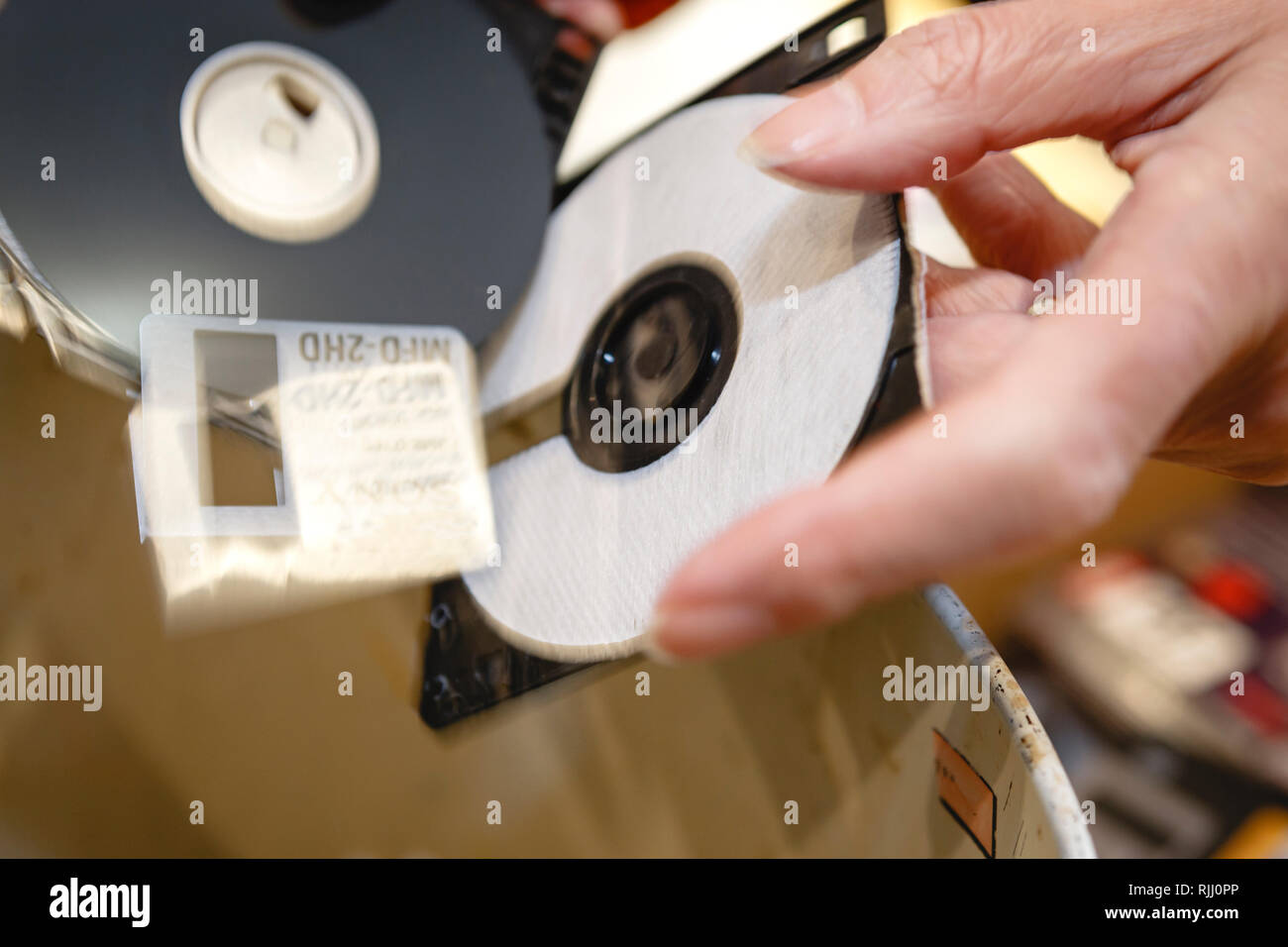 Taglio fino vecchio floppy disc con le forbici per distruggere le informazioni Foto Stock