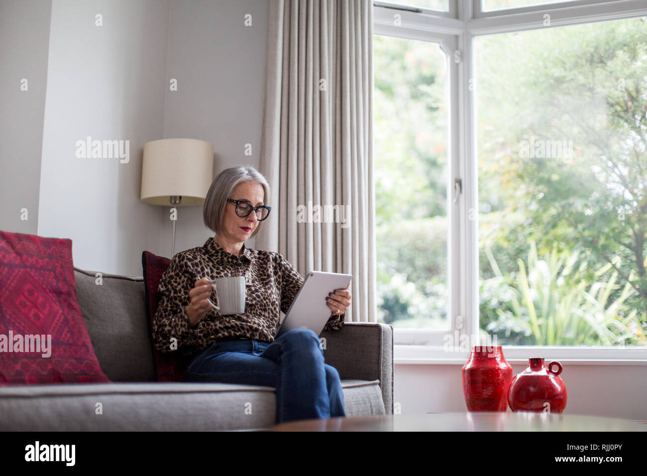 Coppia femmina adulta utilizzando una tavoletta digitale Foto Stock