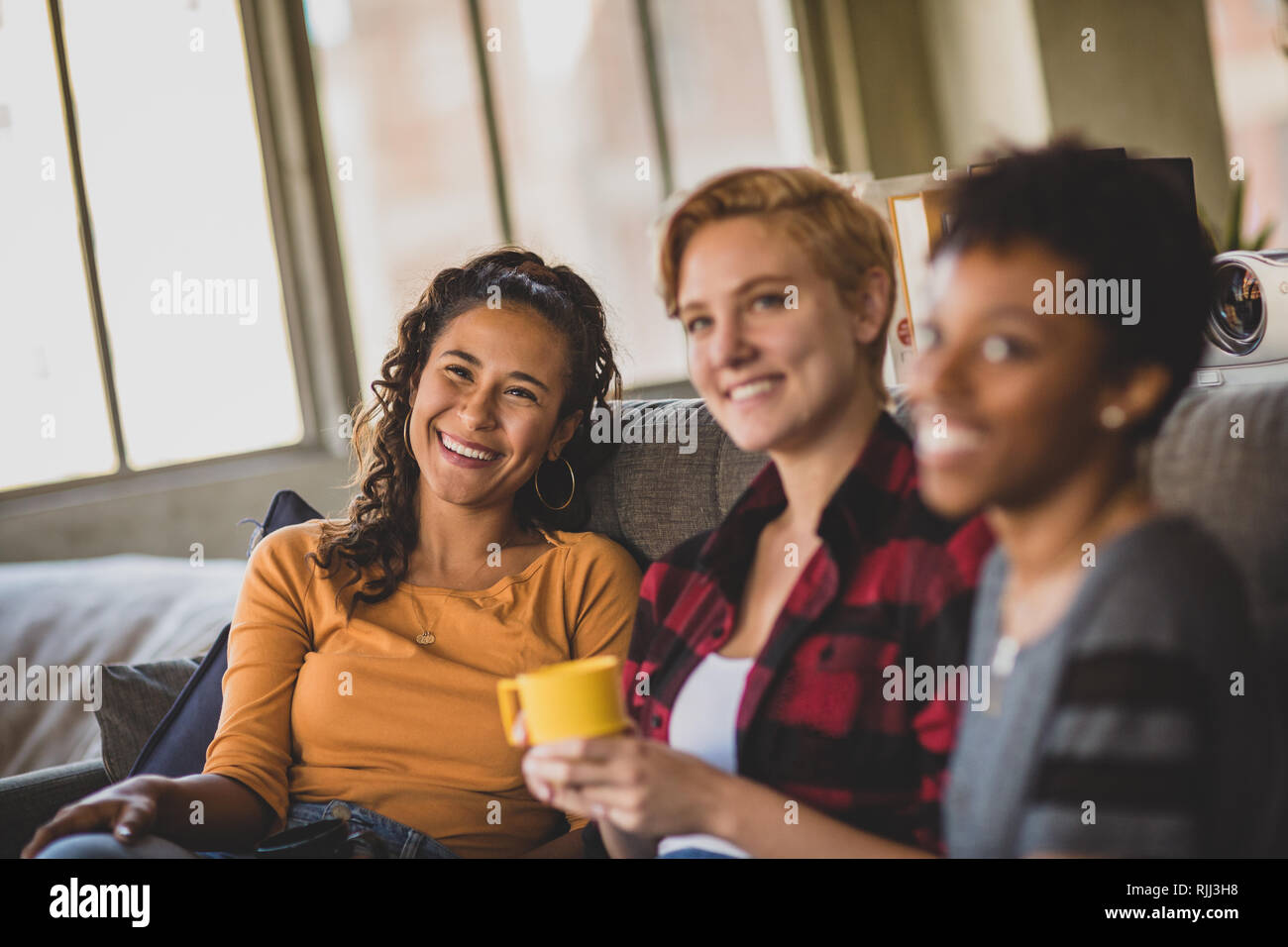 Giovani amici adulti socializzare in un appartamento loft Foto Stock
