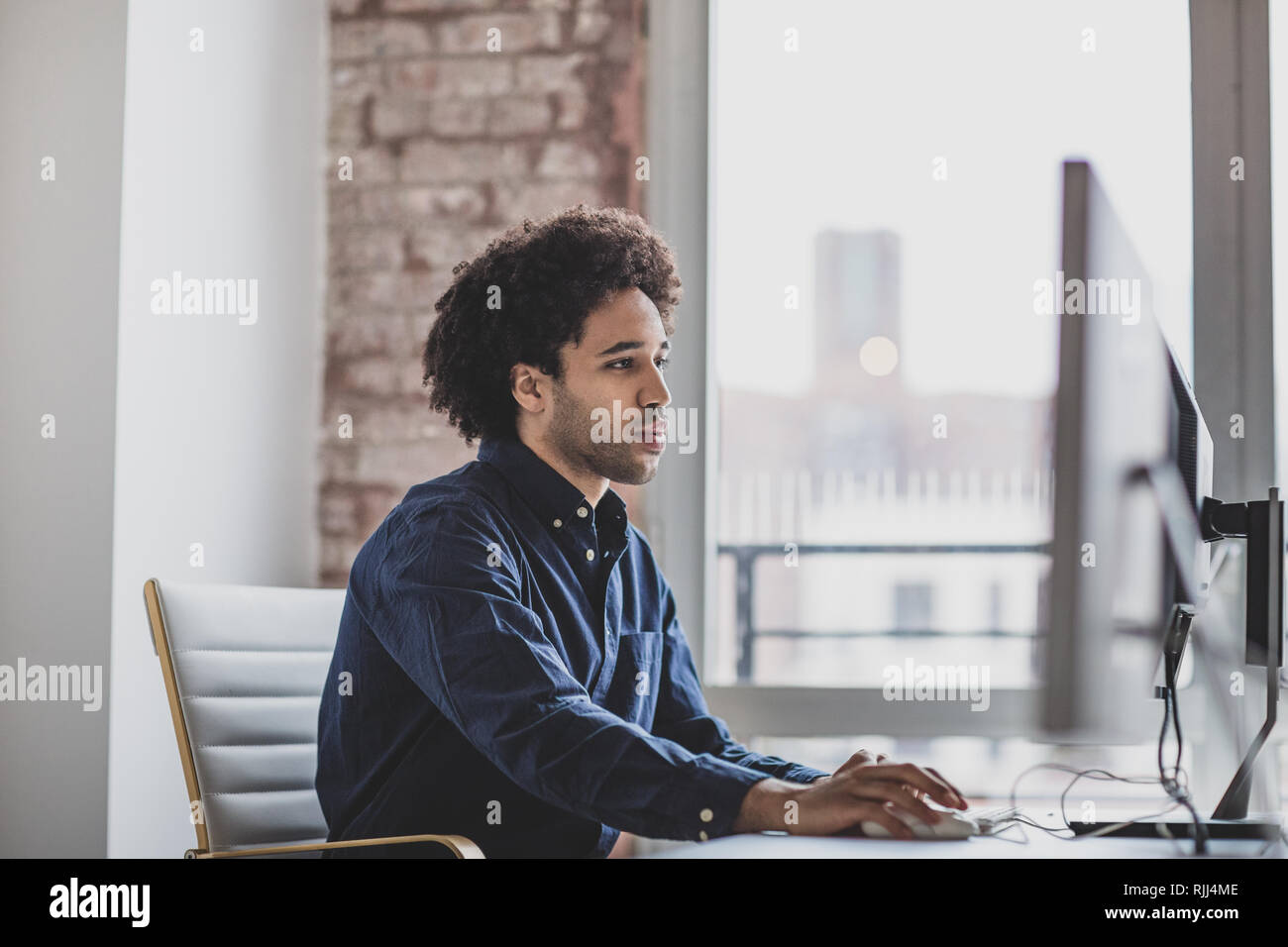 Voce maschile african american business executive lavora in un ufficio su un computer desktop Foto Stock