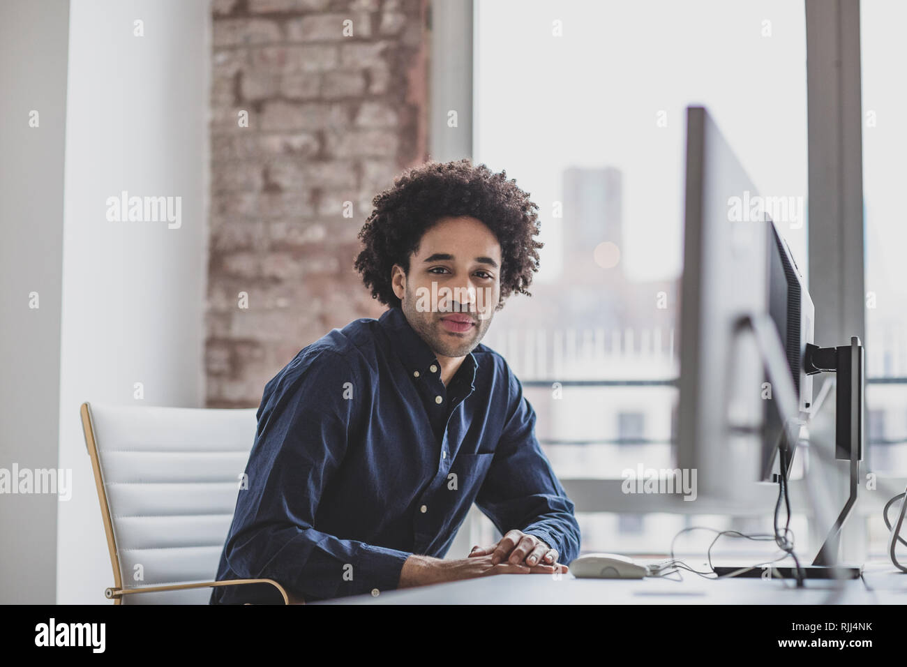 Ritratto di un maschio di African American business executive lavora in un ufficio su un computer desktop Foto Stock