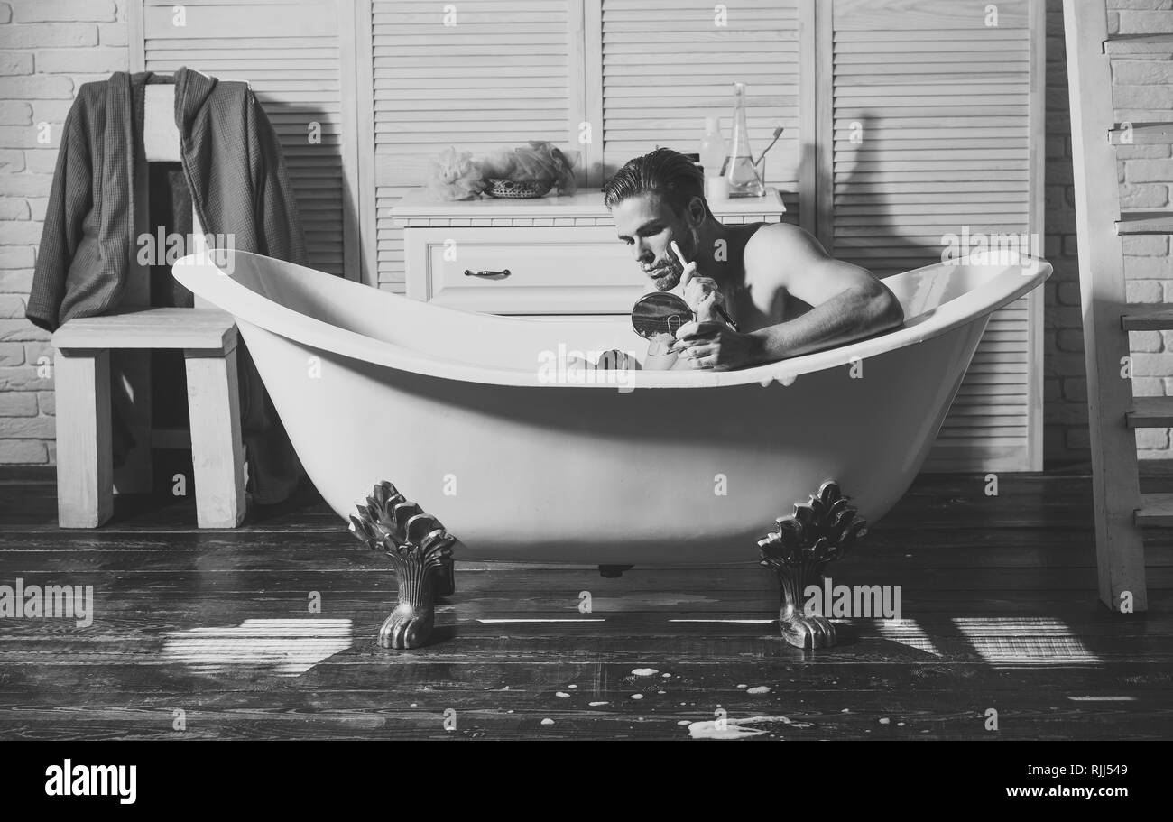 L'uomo per la rasatura con il rasoio, sapone, specchio nella vasca da bagno, Sala da bagno Foto Stock