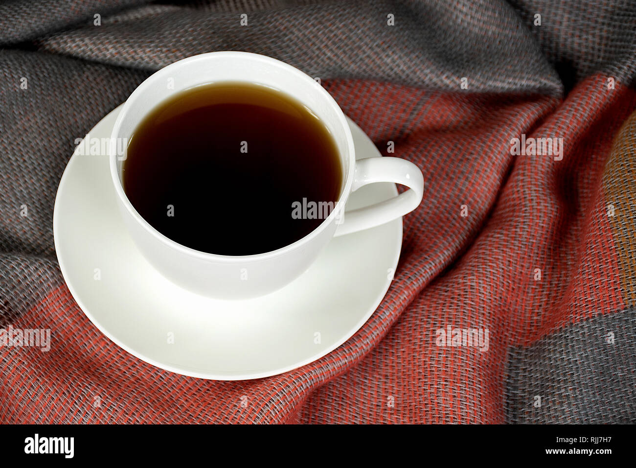 Close up di caffè nero in tazza bianca sul piattino e morbido manto Foto Stock