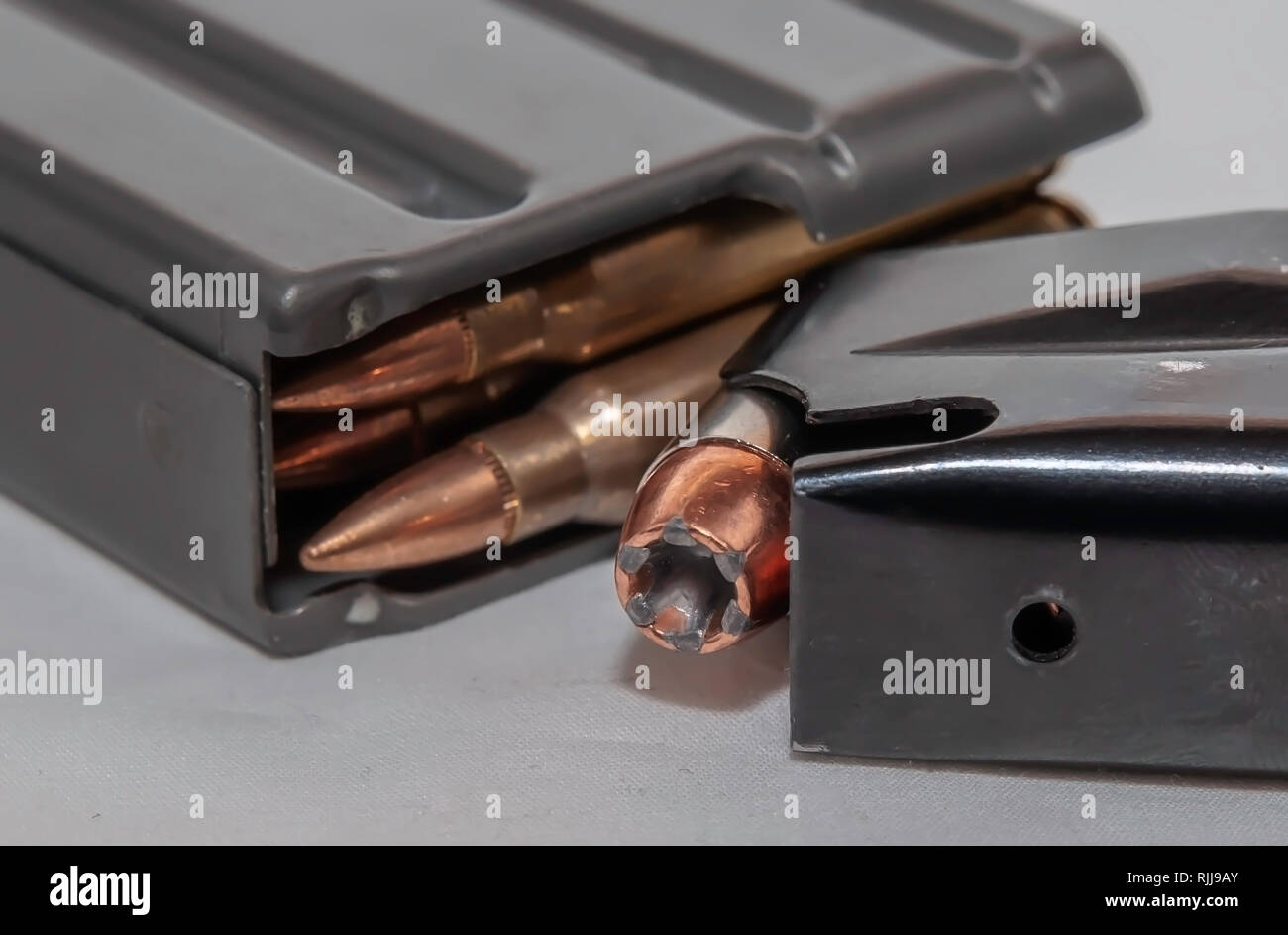 Due arma carica riviste, uno per un 40 pistola calibro e gli altri per un 223 fucile calibro su sfondo bianco Foto Stock