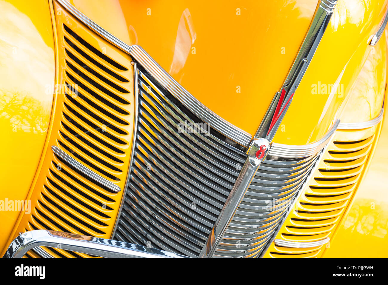 Hook, Regno Unito - 1 Gennaio 2019: Close-up di una griglia cromata e vivido giallo tramonto vernice su un custom Ford V8 hot-asta in Hook, Regno Unito Foto Stock