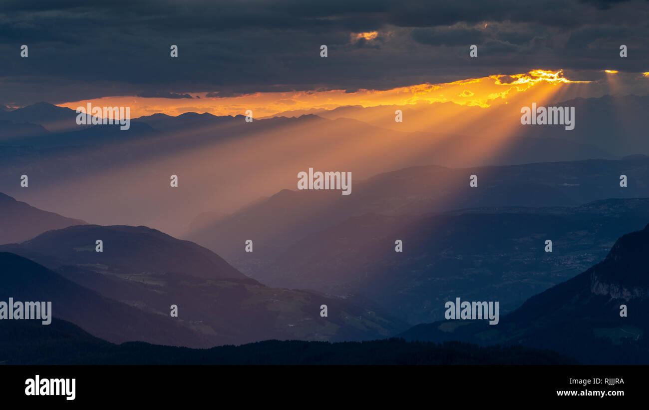 I fasci di luce. La luce del sole al tramonto. Paesaggio di montagna della Valle dell Adige. L'Italia. L'Europa. Foto Stock