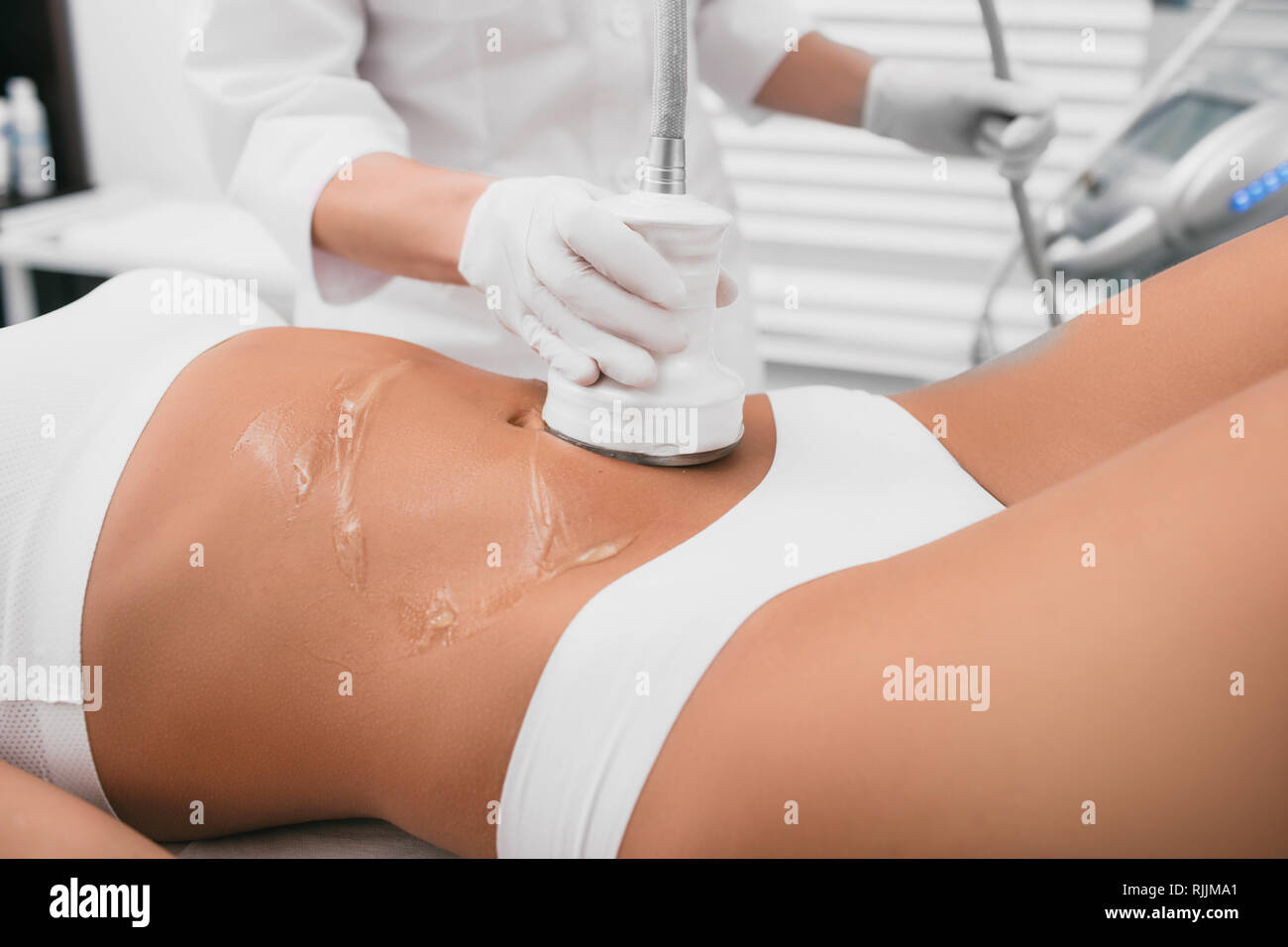 Bella donna avente la cavitazione , trattamento anti cellulite, sul suo ventre alla clinica di bellezza Foto Stock