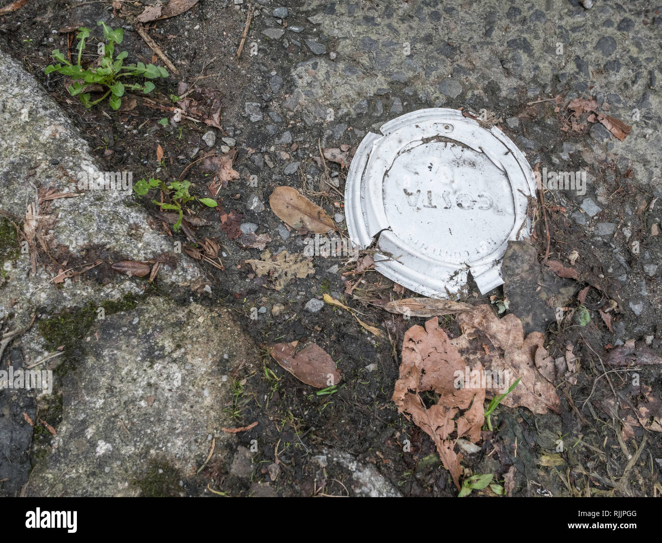 Coperchio della tazza di caffè Costa in plastica schiacciata. Guerra metafora sulla plastica, imballaggi da asporto, inquinamento da lettiere in plastica, tagli ai posti di lavoro Costa Coffee, pulizia della Gran Bretagna. Foto Stock