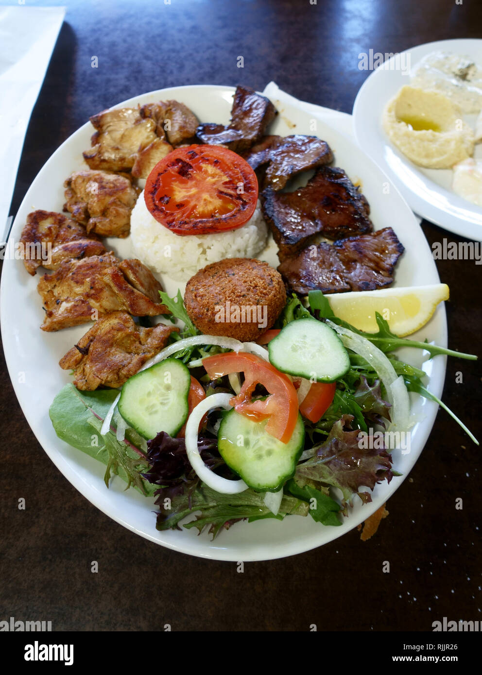 Un piatto di pollo arrosto di agnello serviti con riso in bianco e insalata fresca Foto Stock