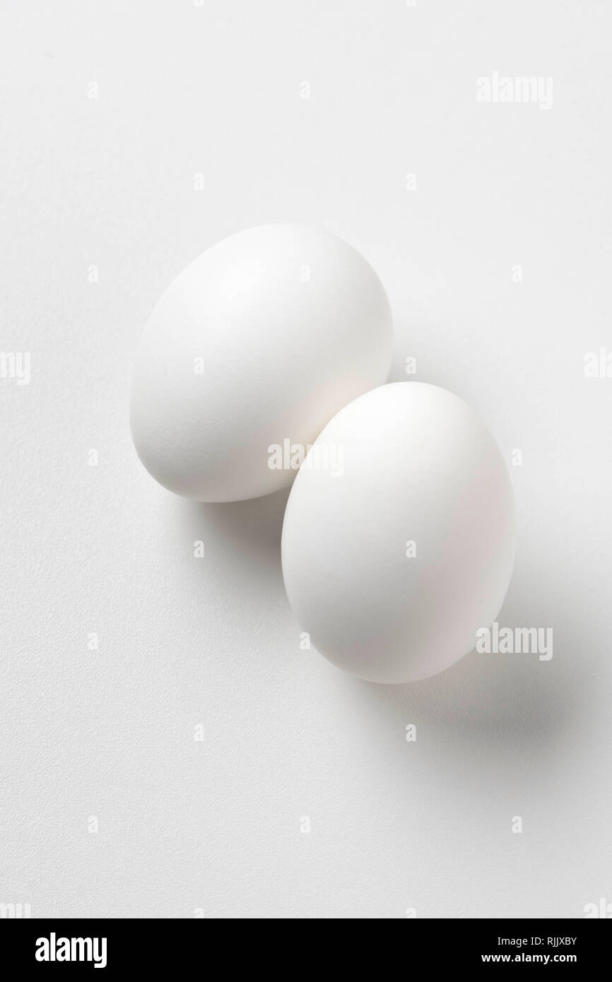 Due uova di colore bianco su bianco Foto Stock
