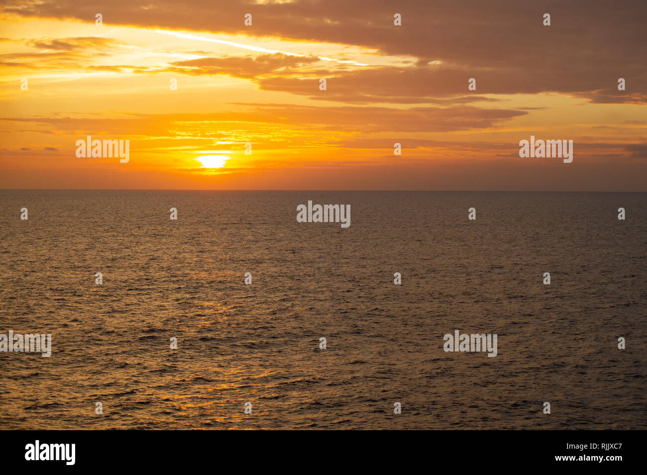 Bella colorato arancione tramonto sul mare di nuvole scure e luminose sun. Concetto di viaggio, Sea Cruises, sfondo all'aperto Foto Stock