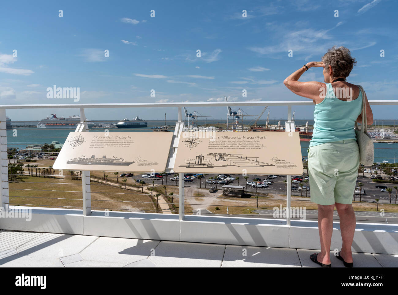 Port Canaveral, Florida, Stati Uniti d'America. Un turista femminile in piedi in un punto panoramico per vedere le attività portuali. Foto Stock