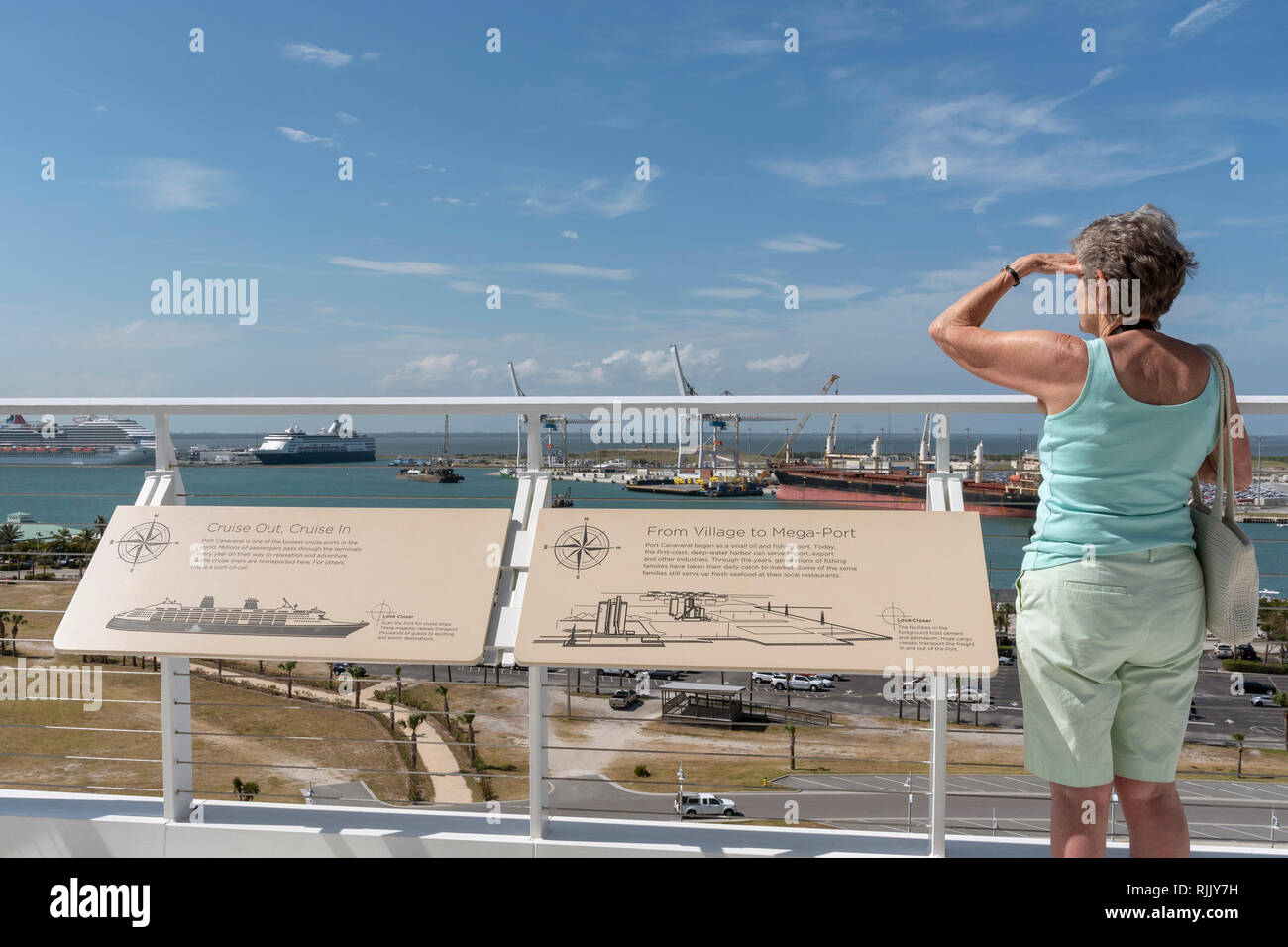 Port Canaveral, Florida, Stati Uniti d'America. Un turista femminile in piedi in un punto panoramico per vedere le attività portuali. Foto Stock
