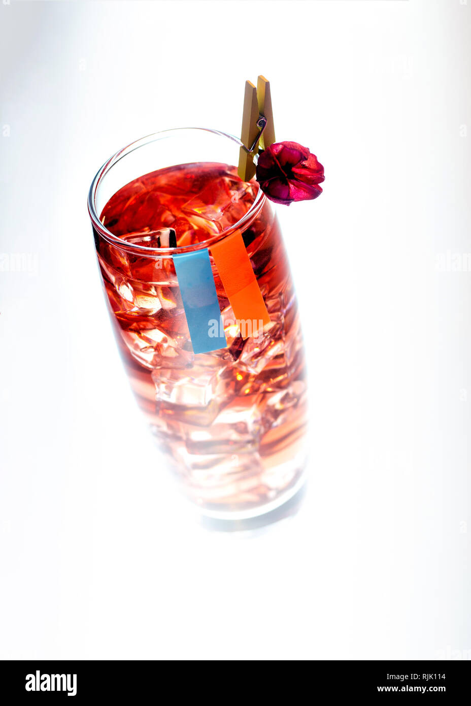 Bere in un bicchiere con ghiaccio e una decorazione sulla clothespin. su uno sfondo bianco. Foto Stock