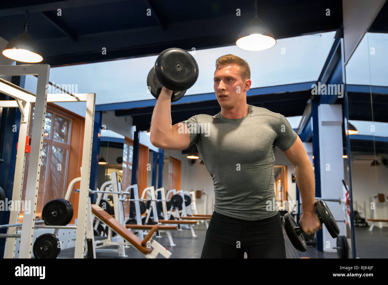 Ritratto atleta maschio treni bicipite in palestra Foto Stock