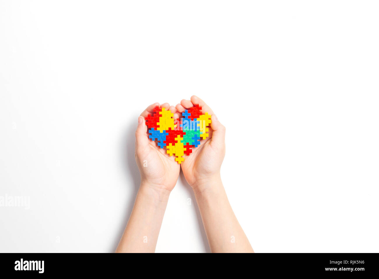 Bambino mani cuore colorato su sfondo bianco. Mondo autismo consapevolezza giorno di concetto Foto Stock