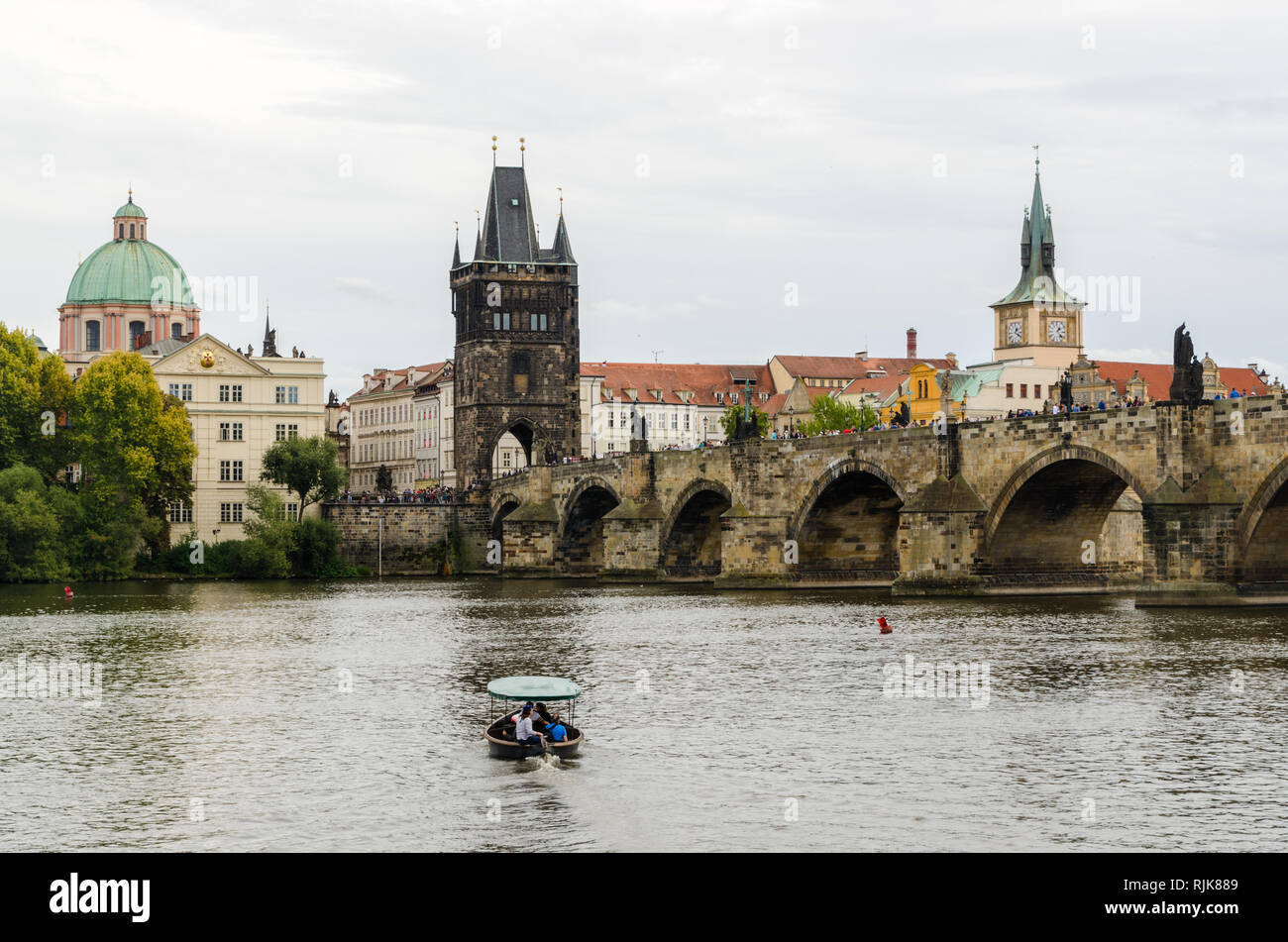 I turisti in una barca sul fiume Vltava nella parte anteriore del ponte Carlo e la torre del ponte della Città Vecchia di Praga, Repubblica Ceca Foto Stock