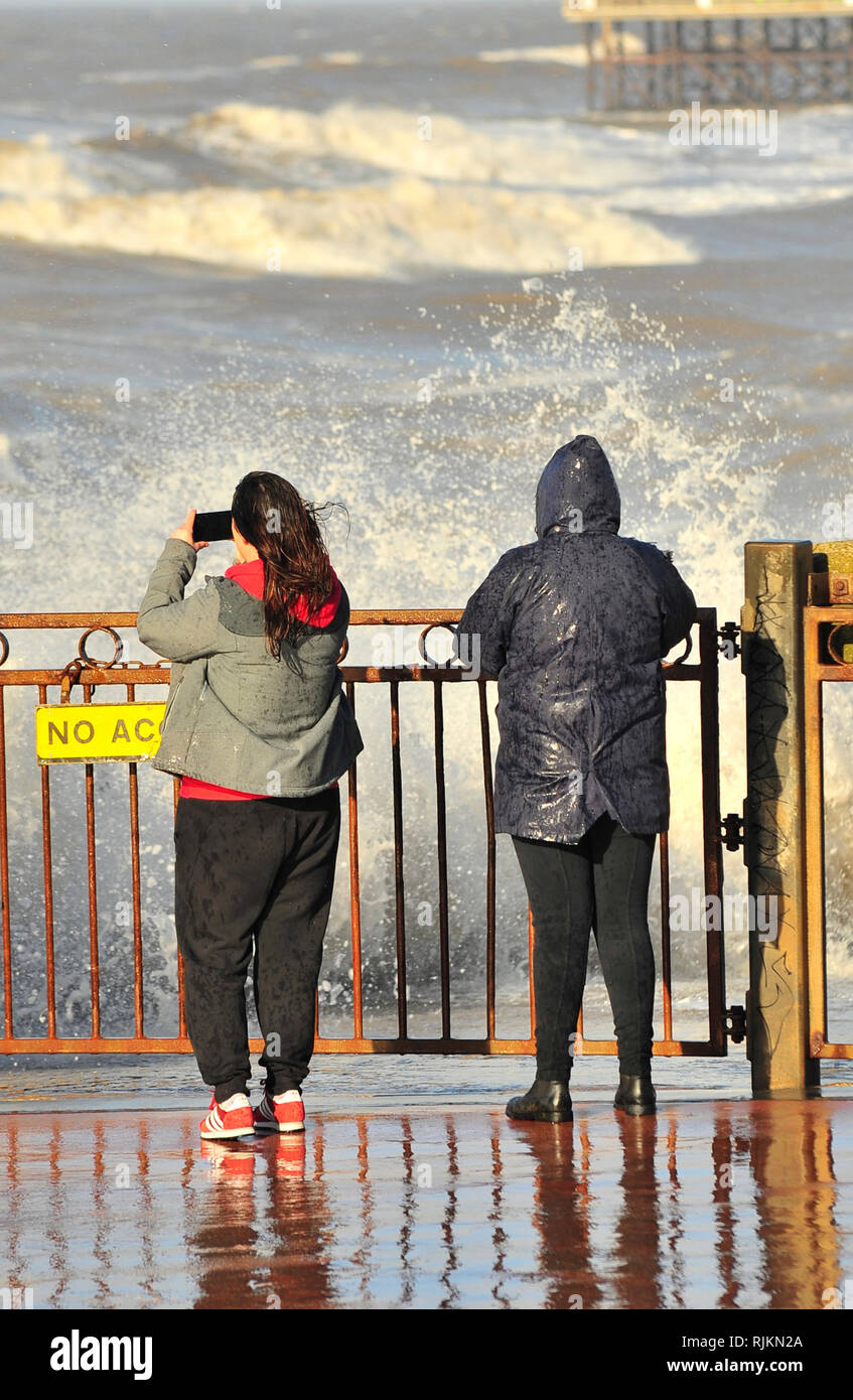 Blackpool, Regno Unito. 7 febbraio 2019. Una combinazione di forti venti e un alta marea prodotto spettacolare mare a Blackpool. Due giovani donne diventava troppo vicino alle onde con i loro telefoni cellulari e ha dovuto dichiarare un ritiro rapido dopo aver ottenuto una buona immersione (3 foto). Kev Walsh Alamy/live news Credito: Kevin walsh Alamy/Live News Foto Stock