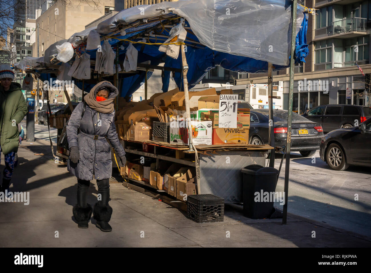 Pedoni nel quartiere di Chelsea di New York a piedi passato una frutta stand privo di frutta, tirato in causa del freddo, giovedì, 31 gennaio 2019. Il freddo pungente che ha afferrato midwestern Stati Uniti è arrivato, leggermente mitigata in New York con un basso di 2 gradi aumenta solo nella metà-adolescenti. (© Richard B. Levine) Foto Stock