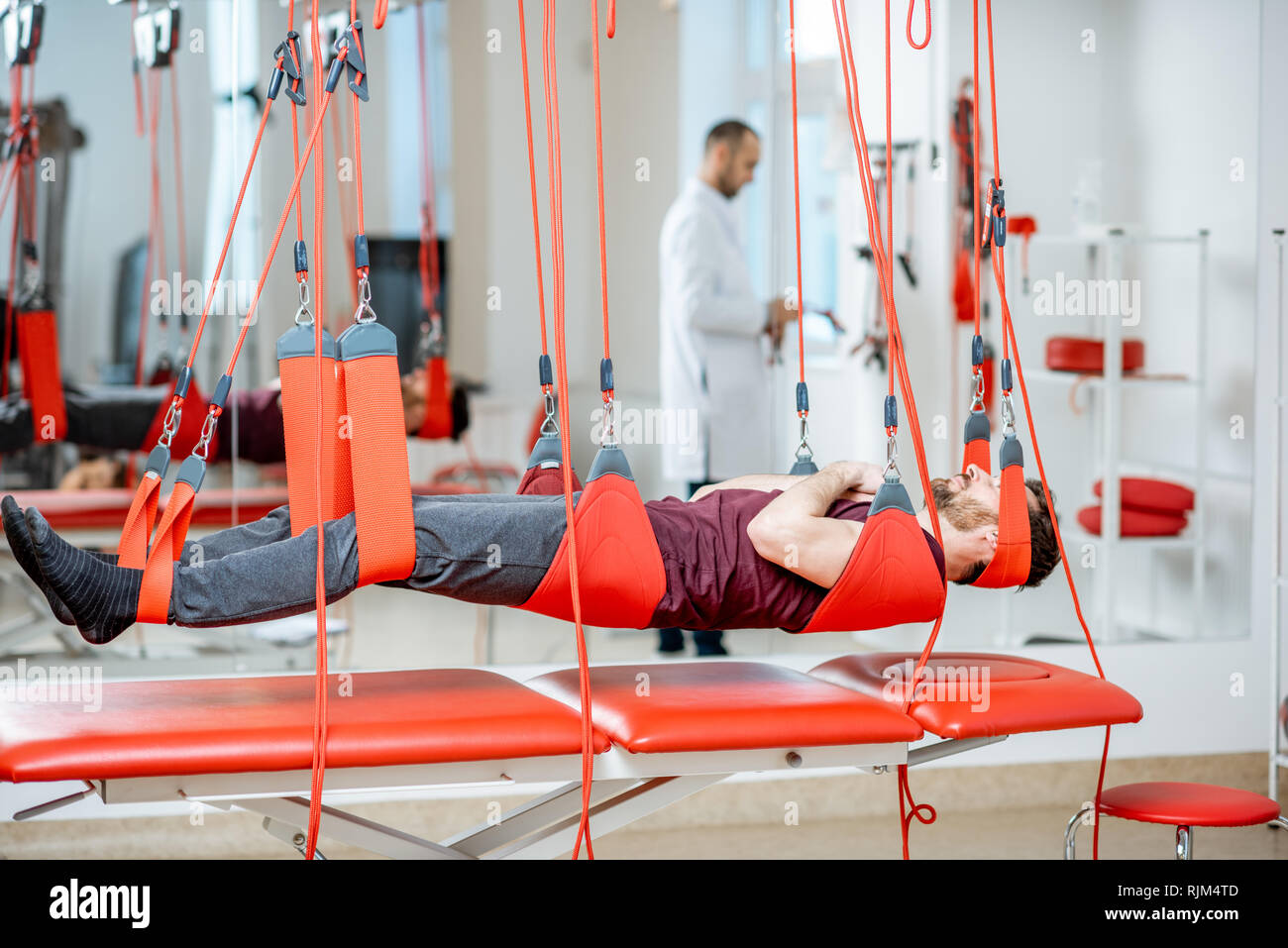 L'uomo appeso alla sospensione di apparecchiature mediche durante il trattamento della colonna vertebrale presso l ospedale di riabilitazione Foto Stock