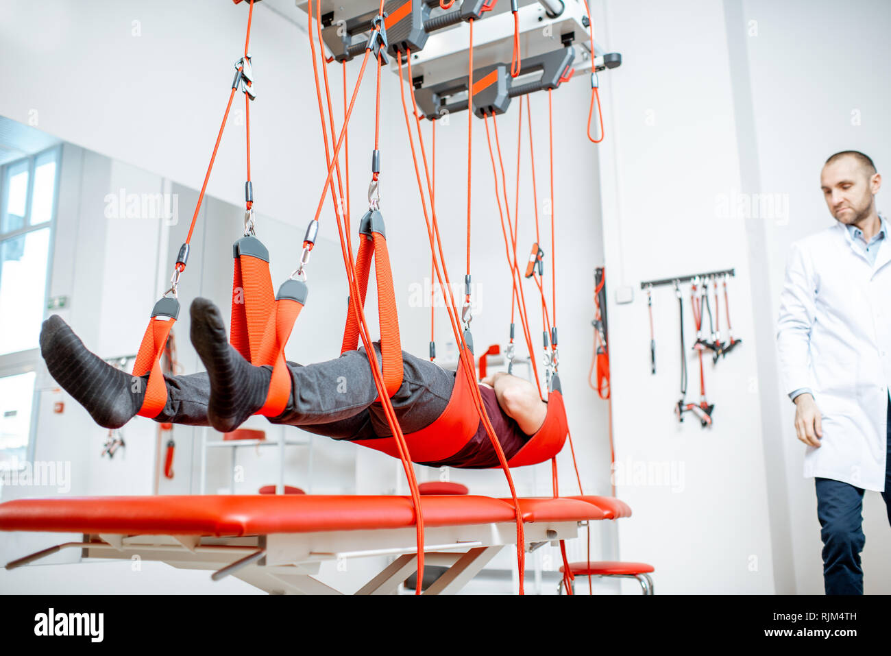 L'uomo appeso alla sospensione di apparecchiature mediche durante il trattamento della colonna vertebrale presso l ospedale di riabilitazione Foto Stock