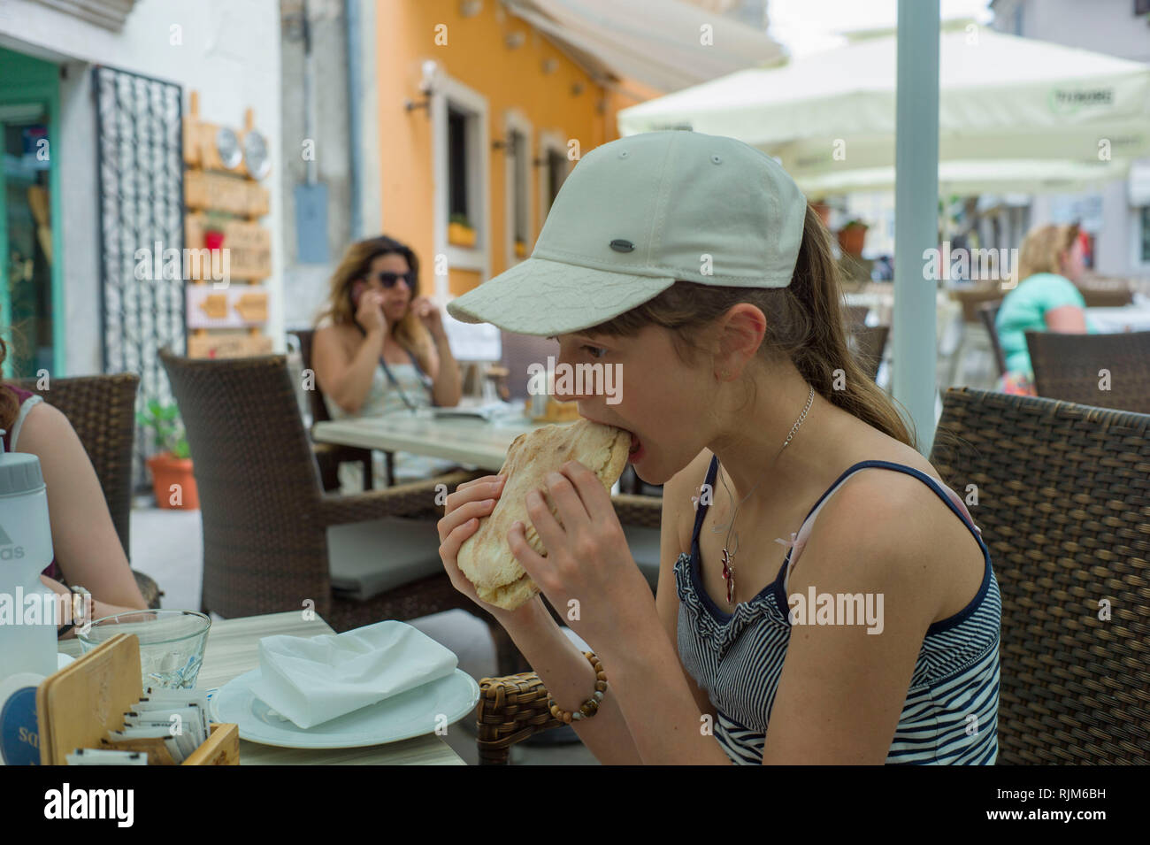 Bambino di mangiare in un bar nel vecchio villaggio di Moscenica, Istria Croazia Foto Stock