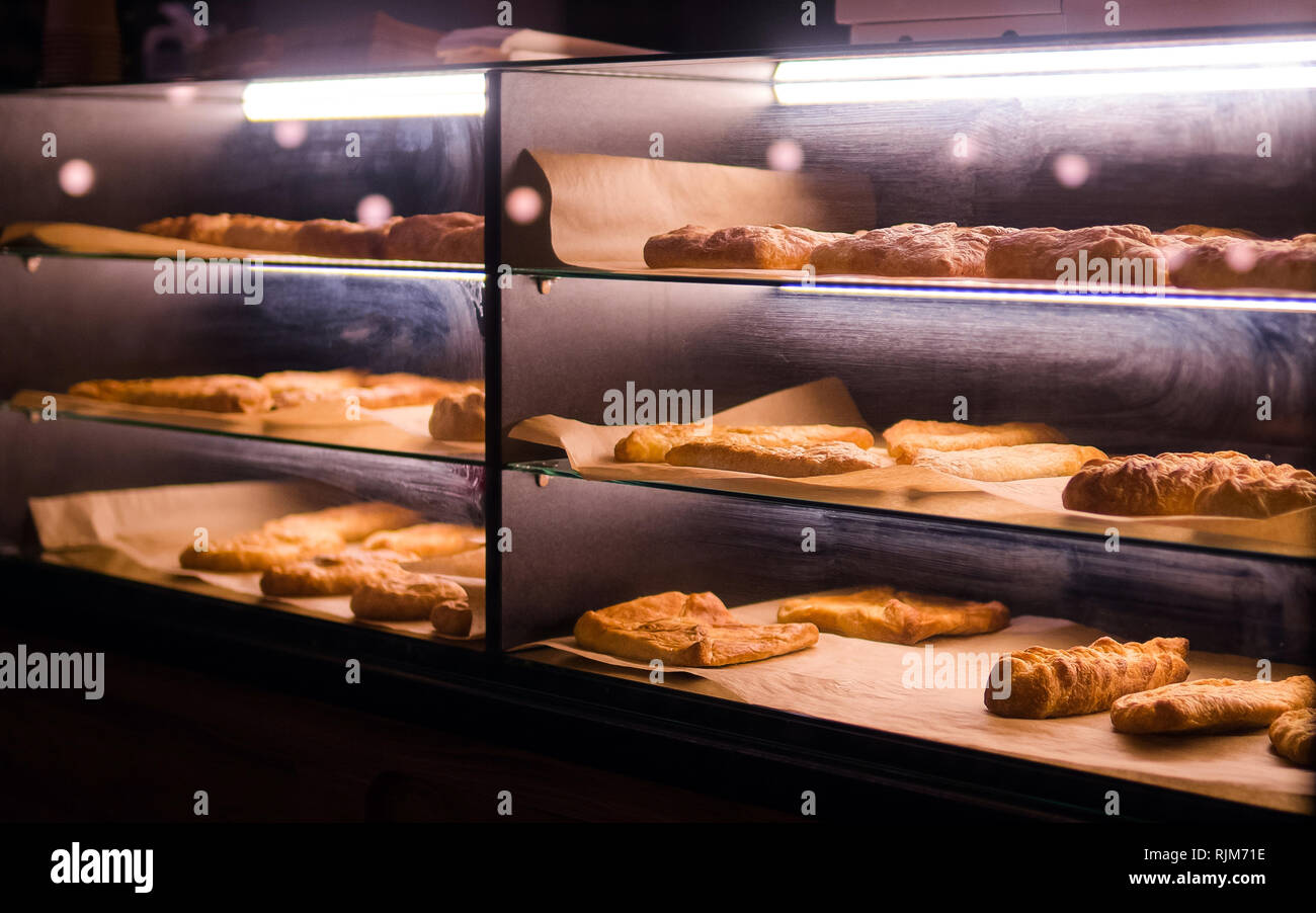 Pasta al forno sotto la finestra di vetro nel forno. Pane, pasticceria nella finestra di visualizzazione. Foto Stock