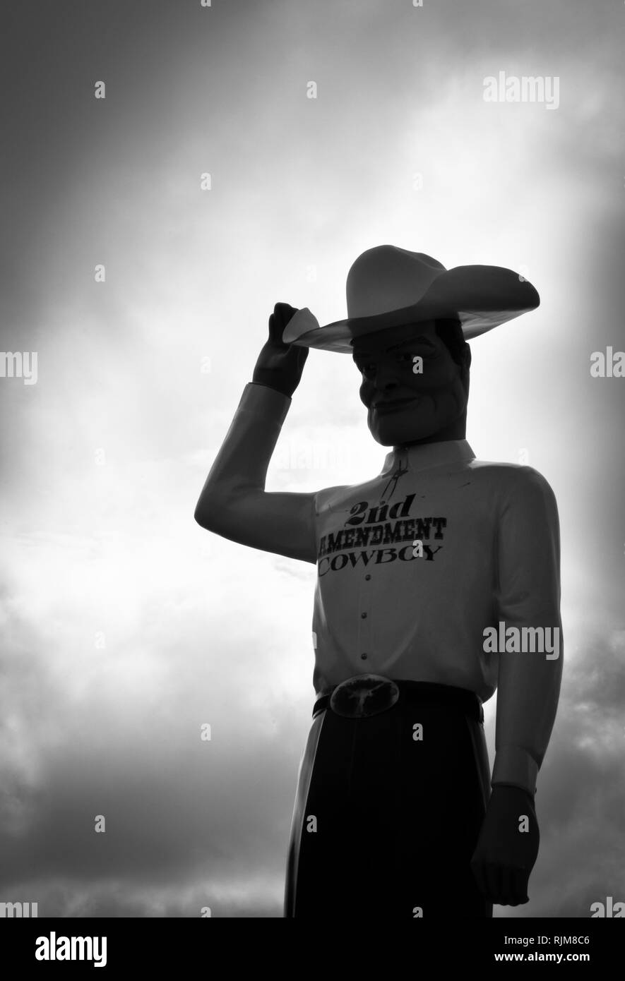 Una gigantesca scultura di un cowboy che indossa una 'seconda emendamento Cowboy' camicia, il suo ribaltamento 10 gallone stetson hat come attrazione sul ciglio della strada vicino a Amarillo, TX Foto Stock