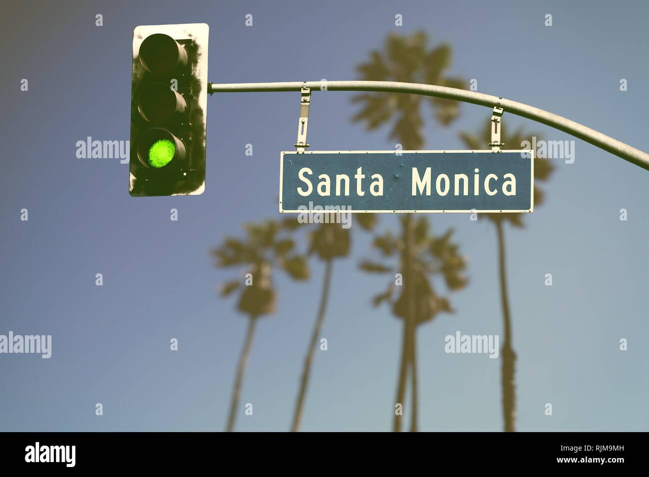 In stile retrò Santa Monica Boulevard cartello stradale con defocalizzata palme in background Foto Stock
