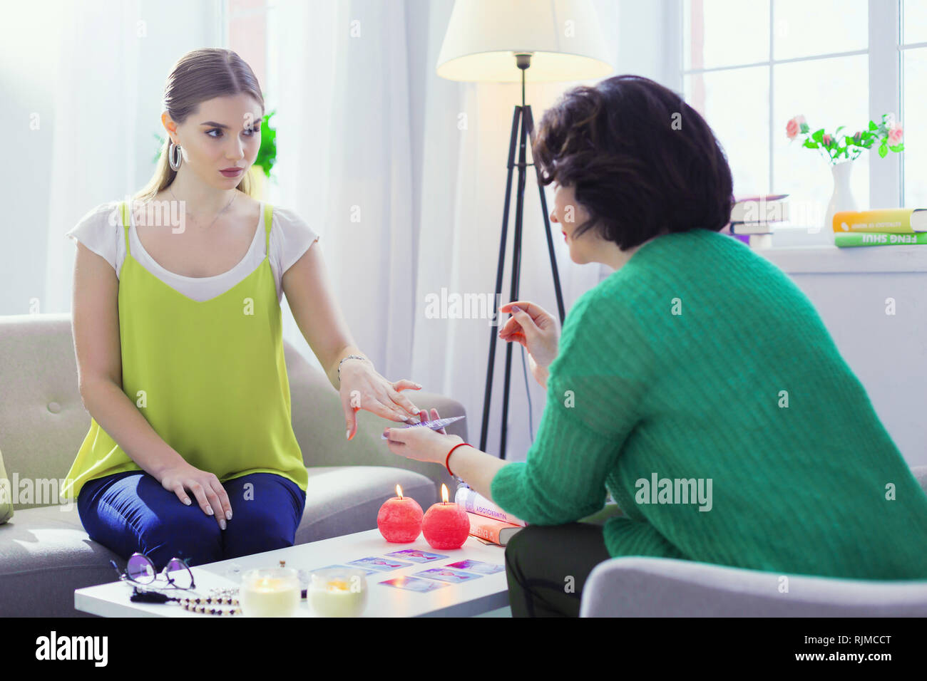 Grave giovane donna guardando le fortune teller Foto Stock