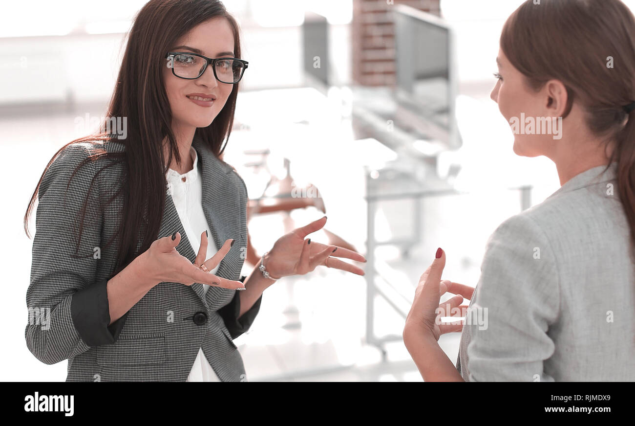 Due dipendenti discutono in piedi in ufficio Foto Stock