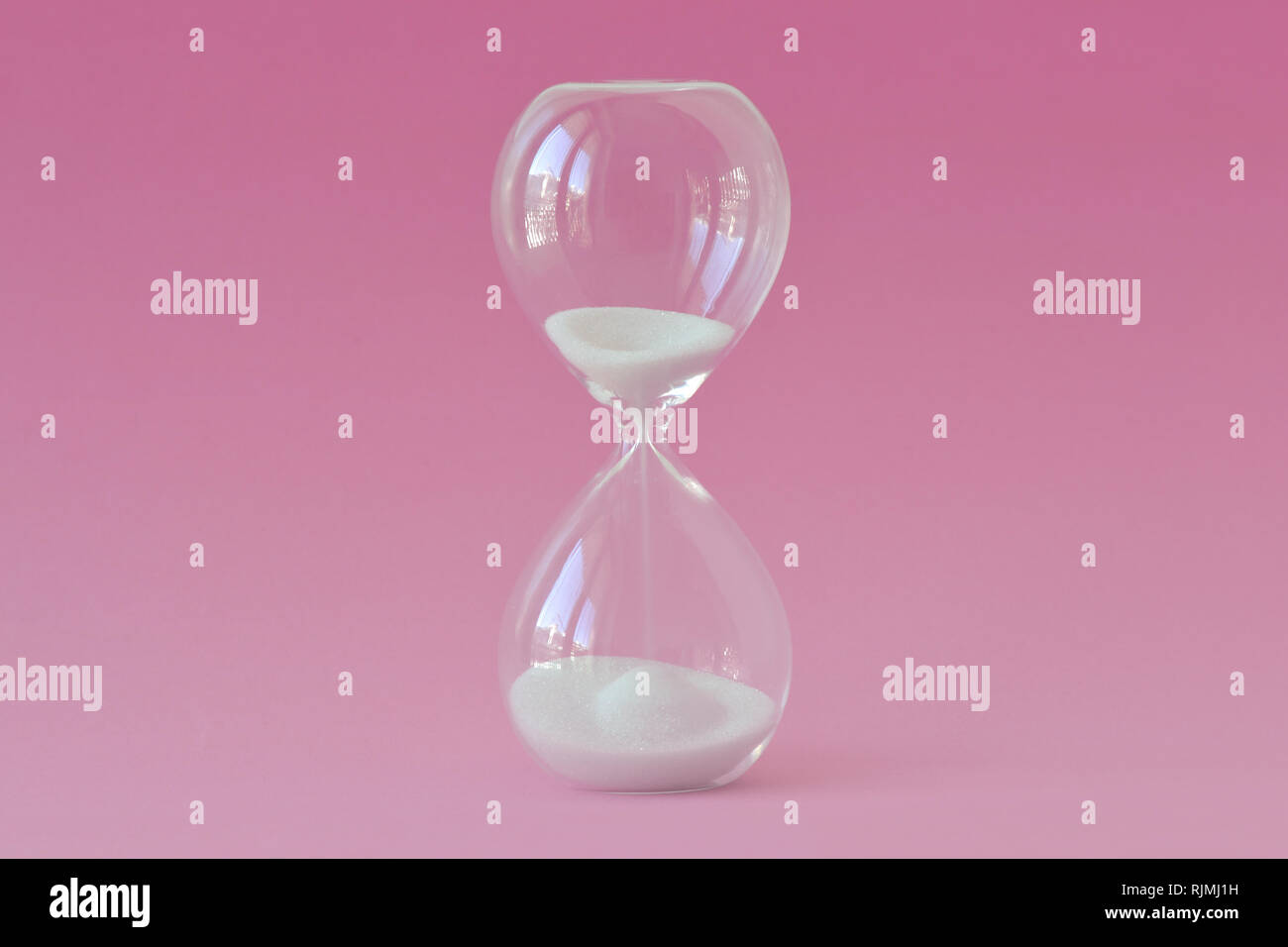 Clessidra su sfondo rosa - Concetto di salute, fertilità e orologio biologico delle donne Foto Stock