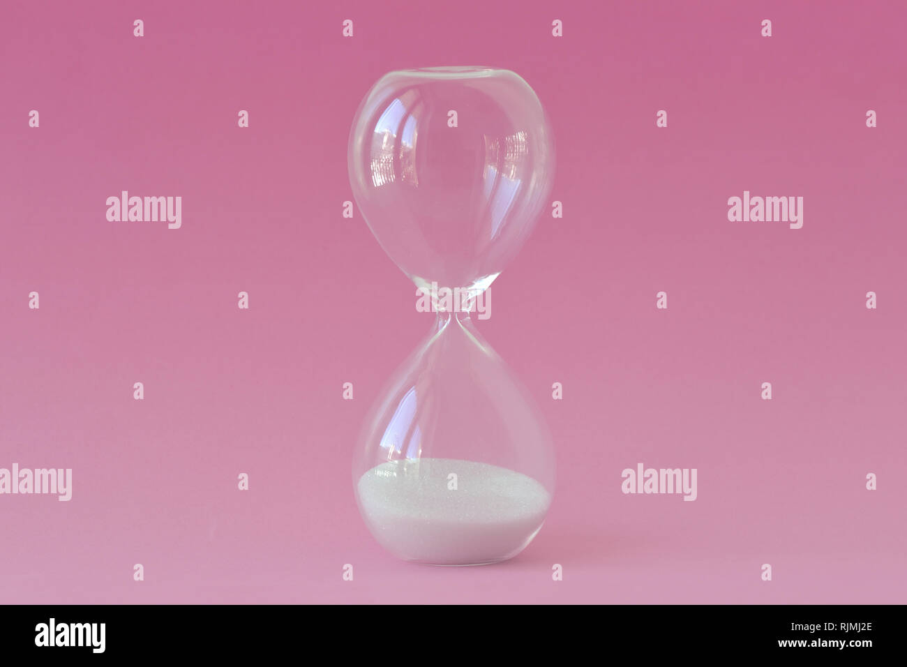 Clessidra su sfondo rosa - Concetto di infertilità e orologio biologico delle donne Foto Stock