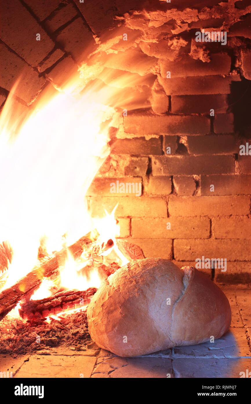 La legna brucia in un vecchio forno per la cottura del pane Foto Stock