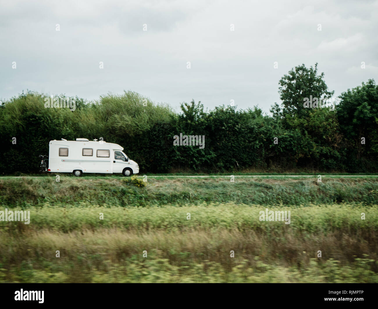 White motorhome RV Camping van guida veloce - camper van la guida in verde pulito ambiente ecologico per il campeggio tempo libero Foto Stock