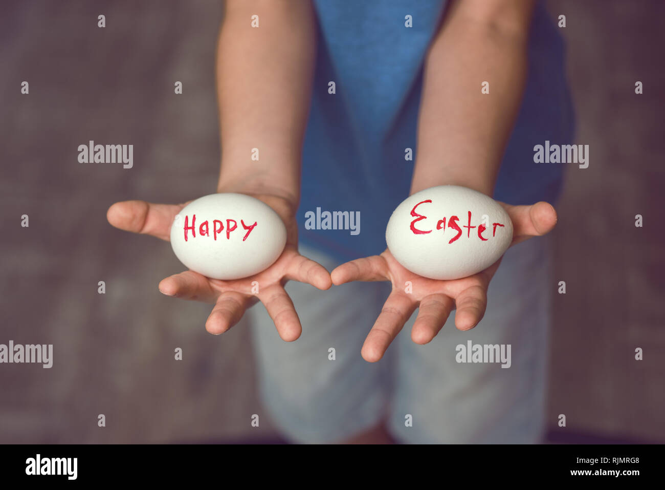 Uova con la scritta buona Pasqua il bambino tiene nelle sue mani davanti a lui. Foto Stock