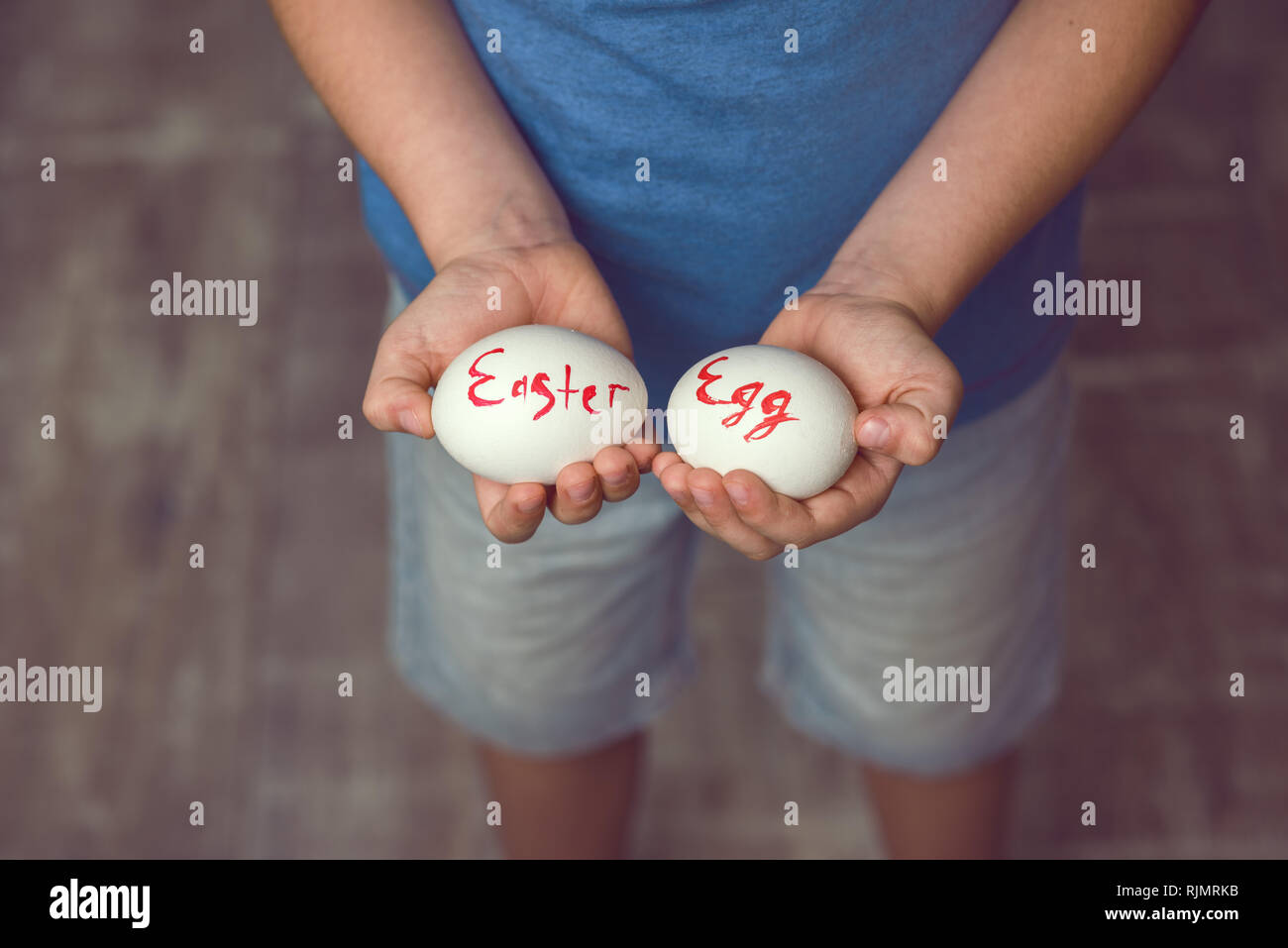 Uova con la scritta buona Pasqua il bambino tiene nelle sue mani davanti a lui. Foto Stock