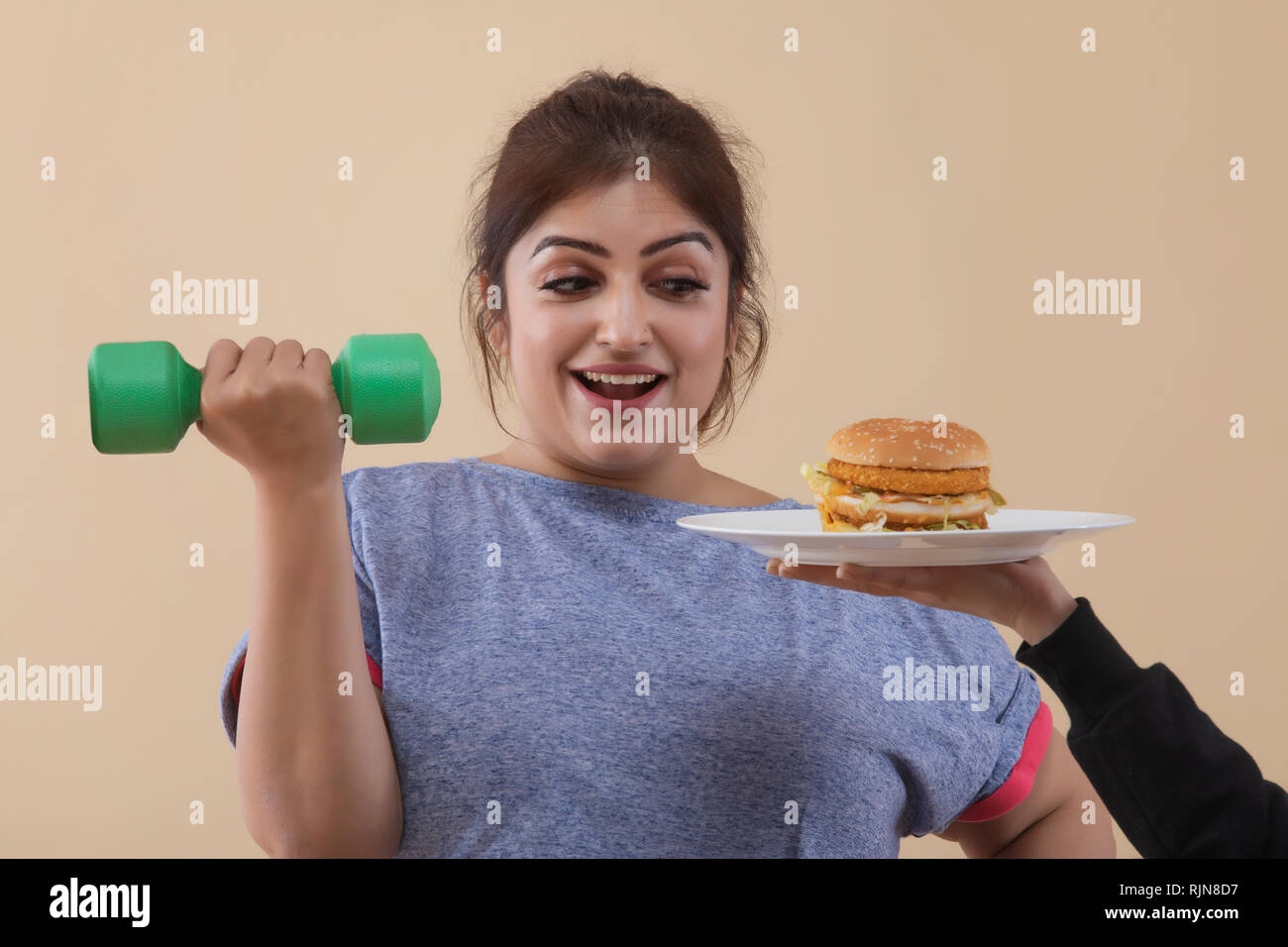 Excited donna sovrappeso esercizio ritagliate dando mano Burger Foto Stock